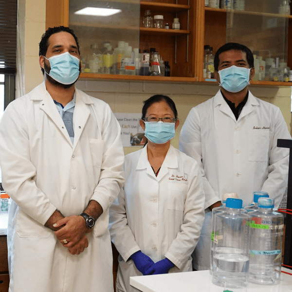 group of three researchers from Tuskegee University in the lab wearing masks