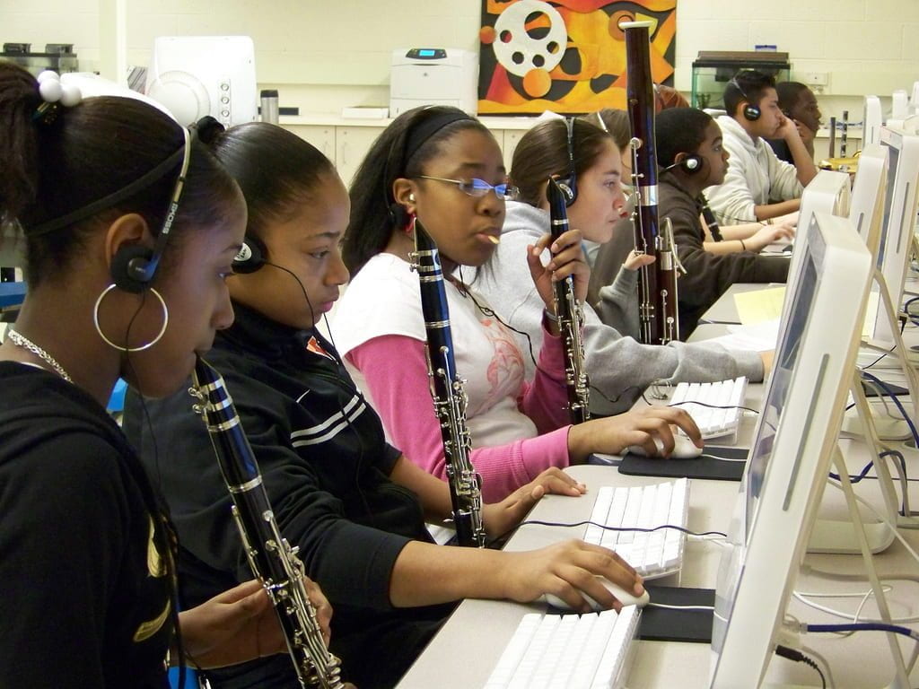 a picture of girls playing clarinets while in a computer lab