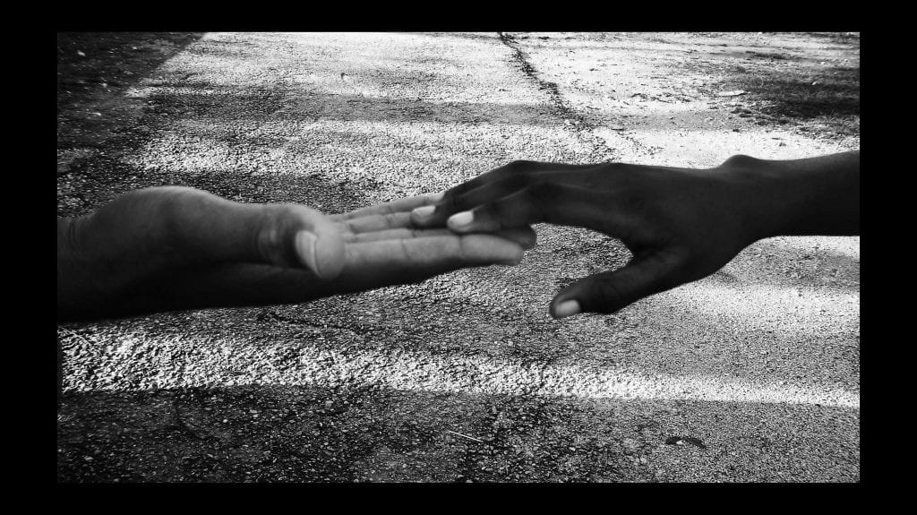 a picture of two people touching hands in unity