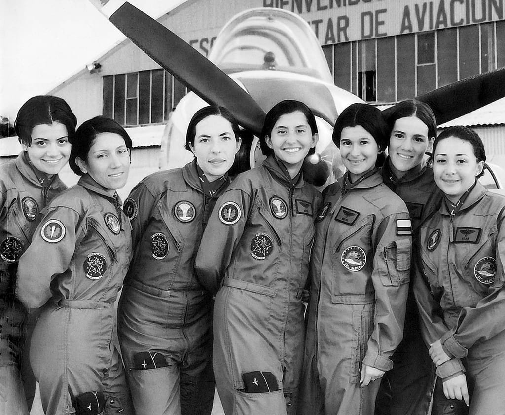 The first seven female pilot officers of the Colombian Air Force against a T-34