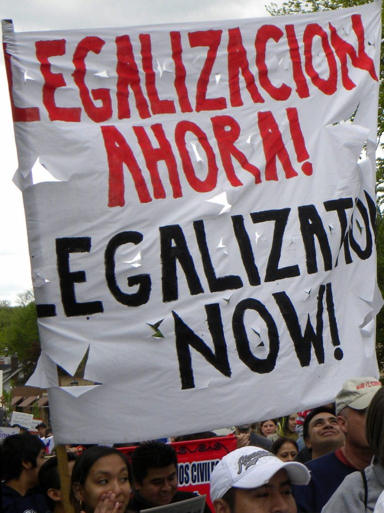 A ripped banner that says, "Legalizacion Ahora!" and then "Legalization Now!"