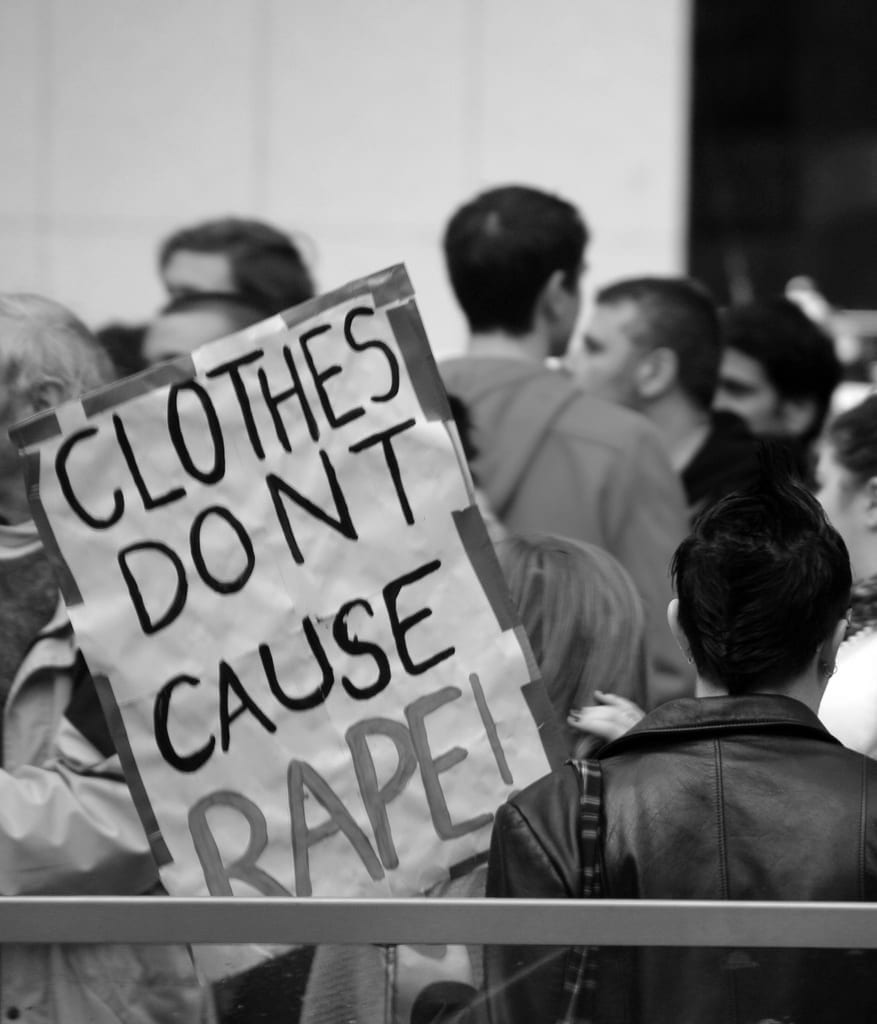 a picture of a sign that reads "clothes don't cause rape"