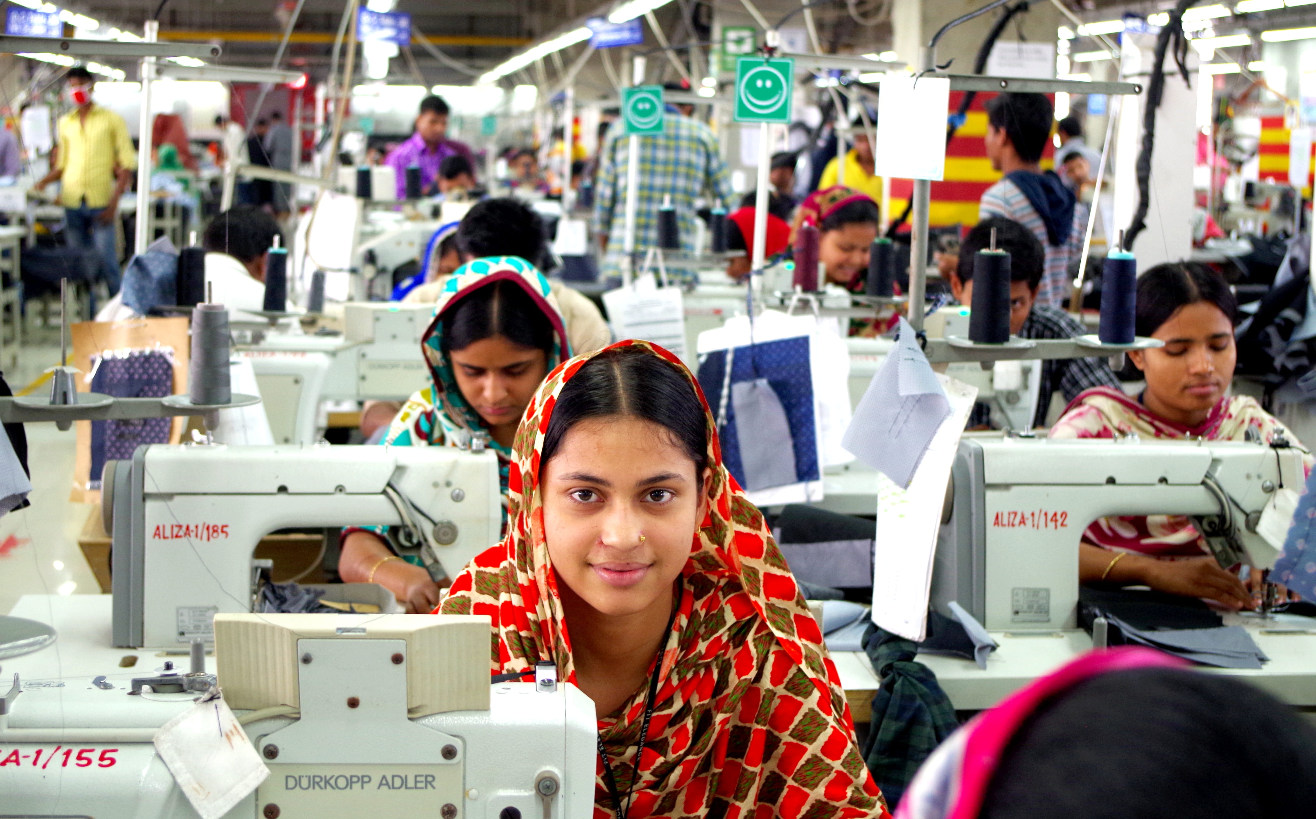 Garment workers working at sewing machines in a factory in Gazipur, Bangladesh.