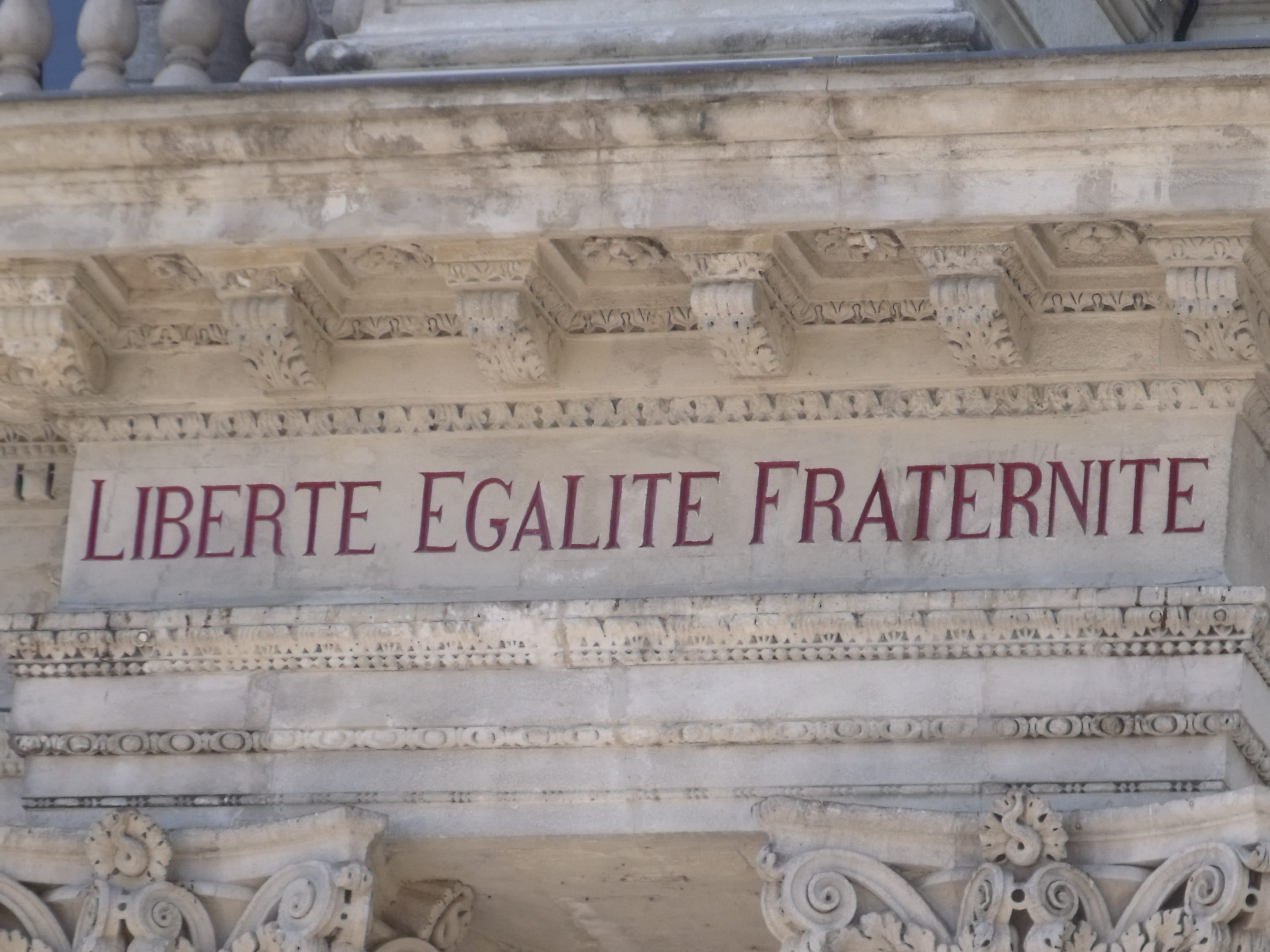 The words "liberte egalite fraternite" written above the entrance to the Hôtel de Ville in Avignon, France.