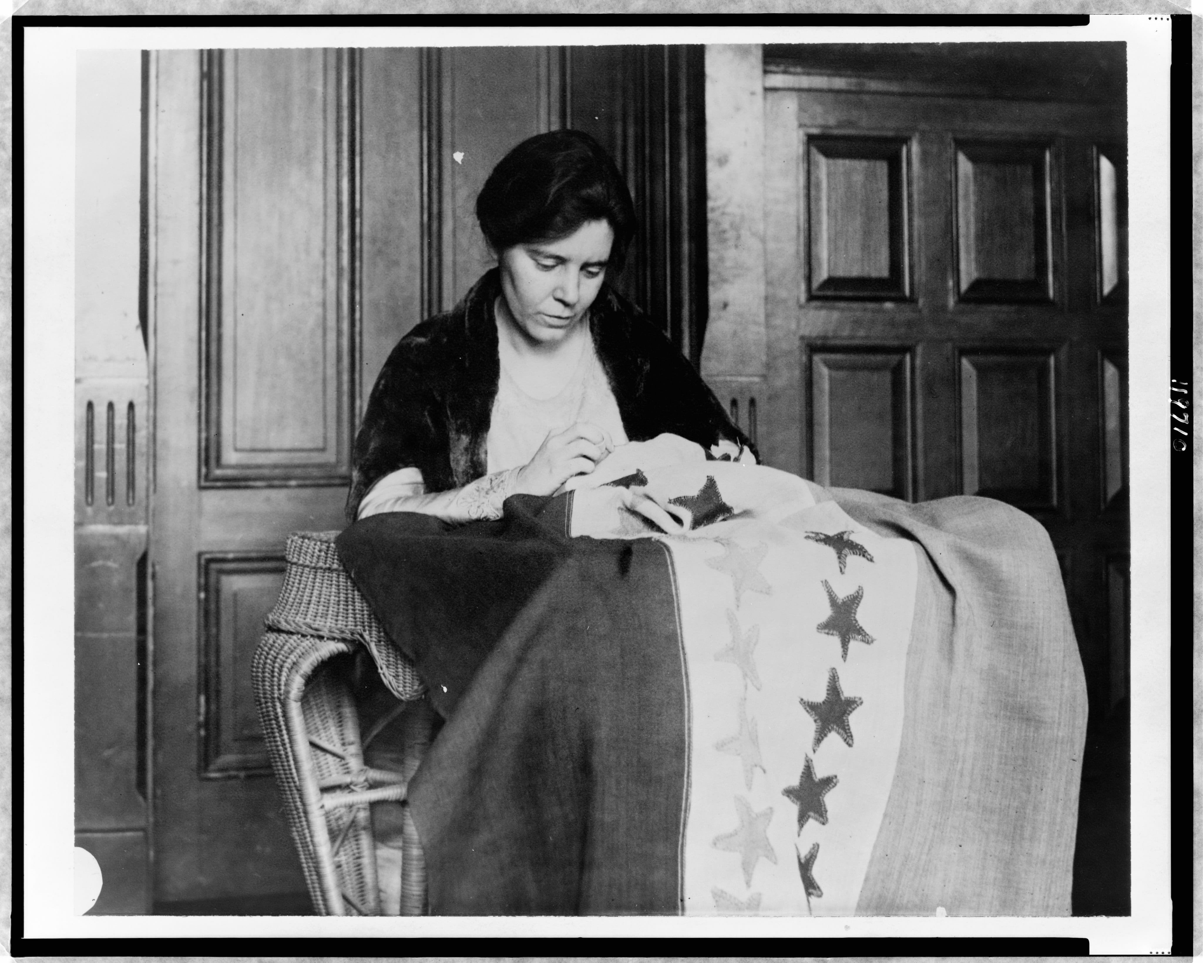 a photo of Alice Paul sewing the Suffrage flag