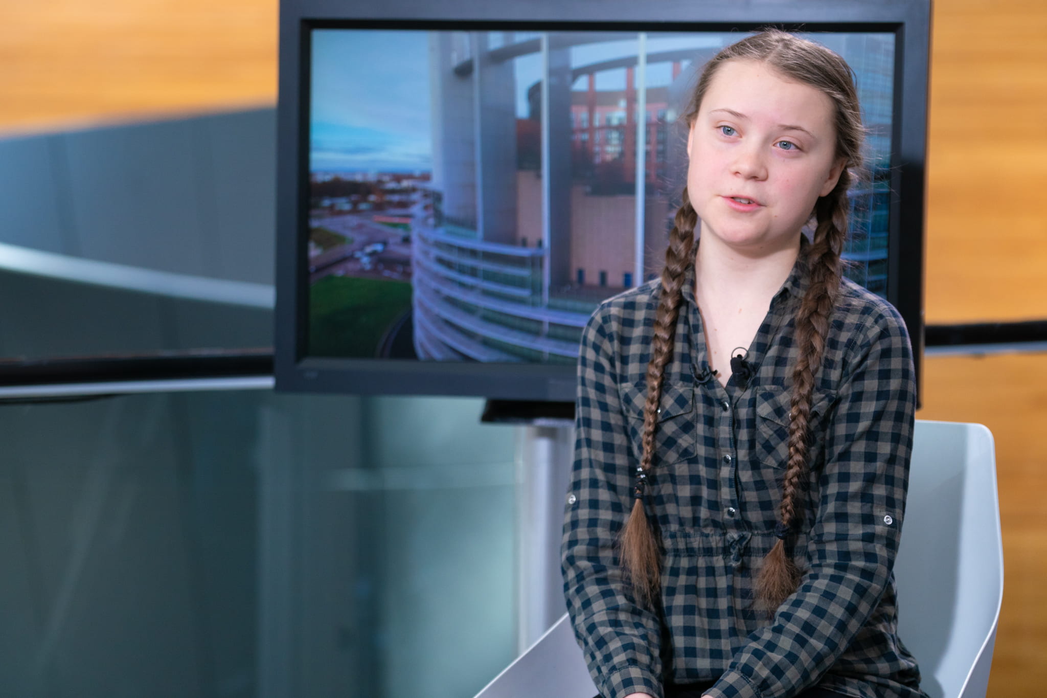 Greta Thunberg sitting in a chair and being interviewed.