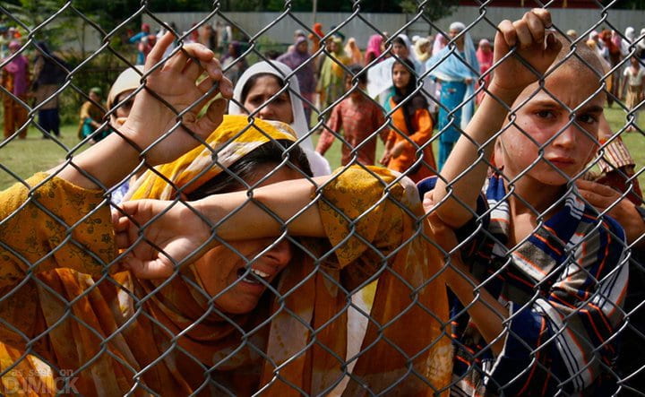 Devastated Kashmiri girls crying while holding on to fence