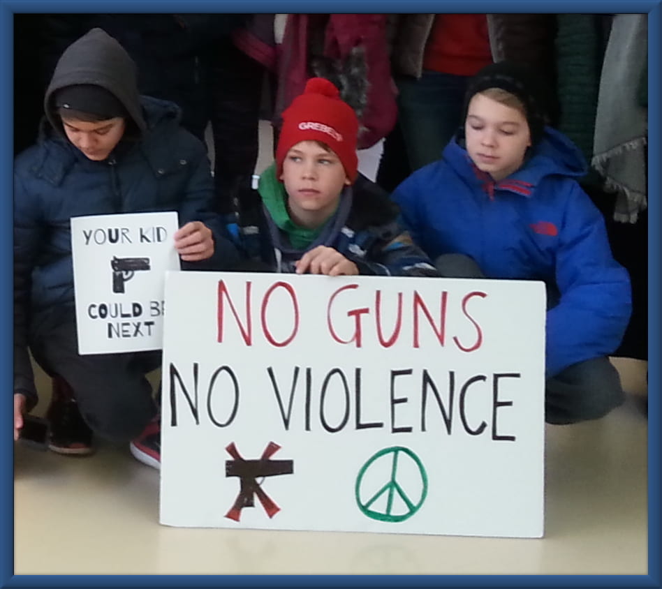An image of three kids surrounding a sign that says No Guns No Violence.