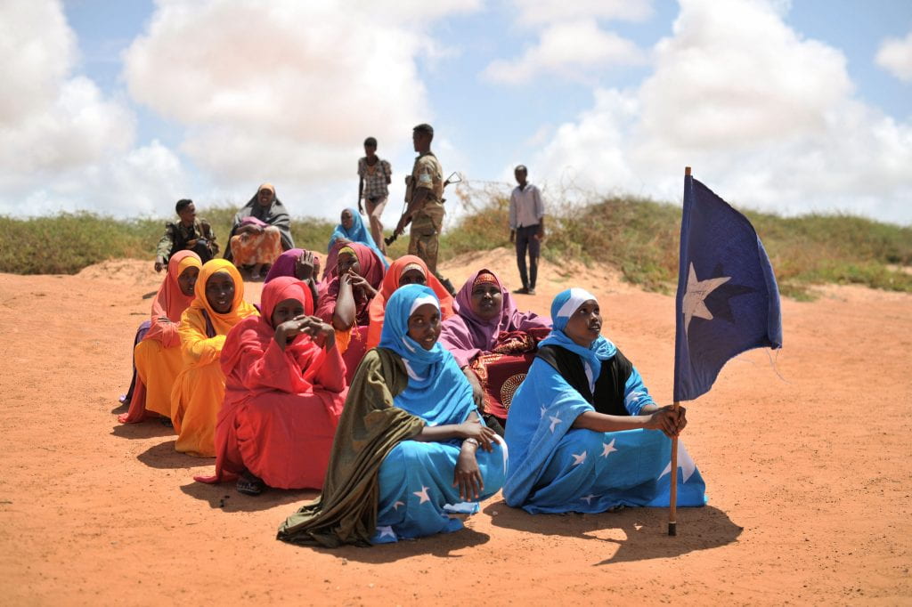 A young woman holds the Somali flag during a demonstration by a local militia, formed to provide security in Marka, Somalia
