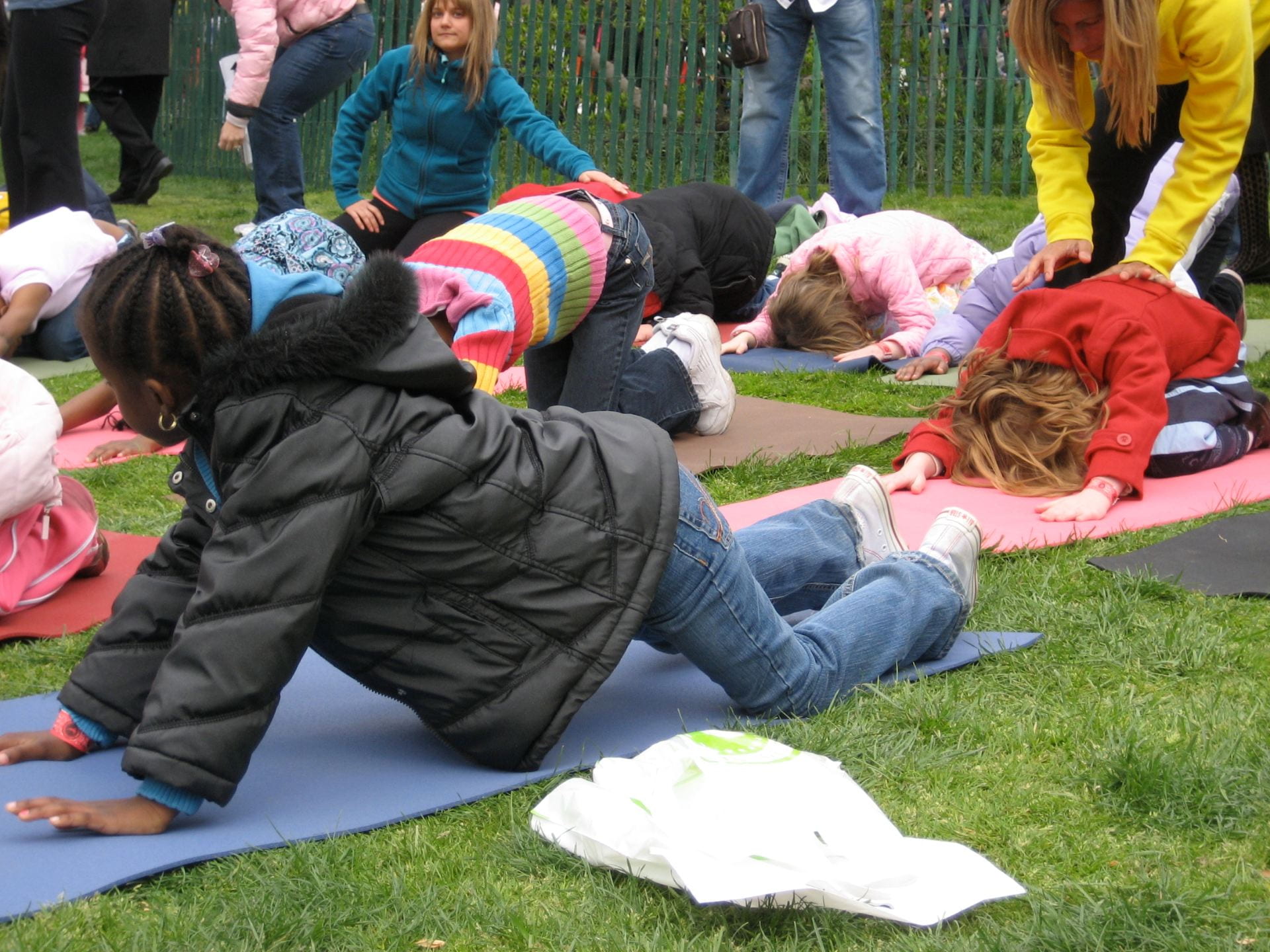 Children learning yoga outside.