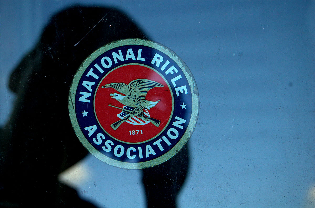 A man photographs the National Rifle Association logo.