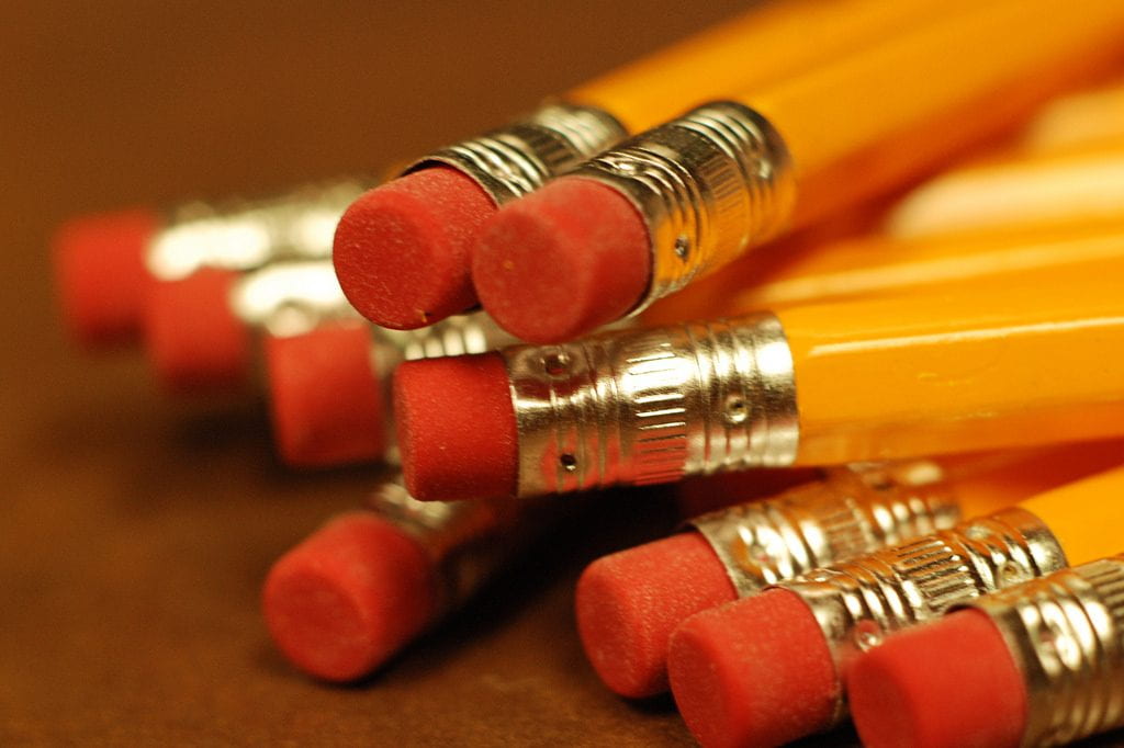 The eraser ends of a pile of pencils.