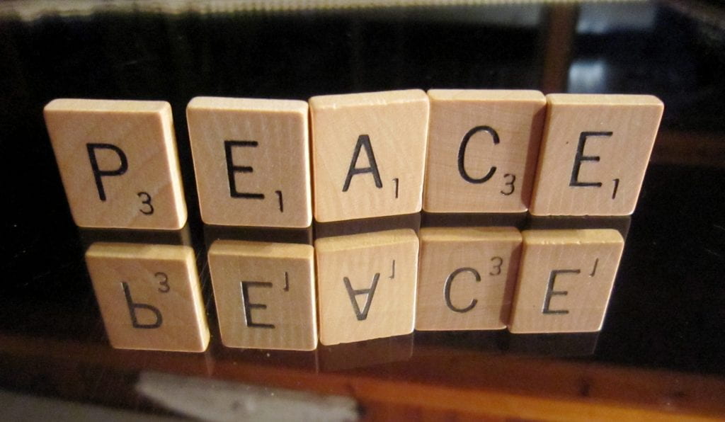 scrabble pieces that spell PEACE