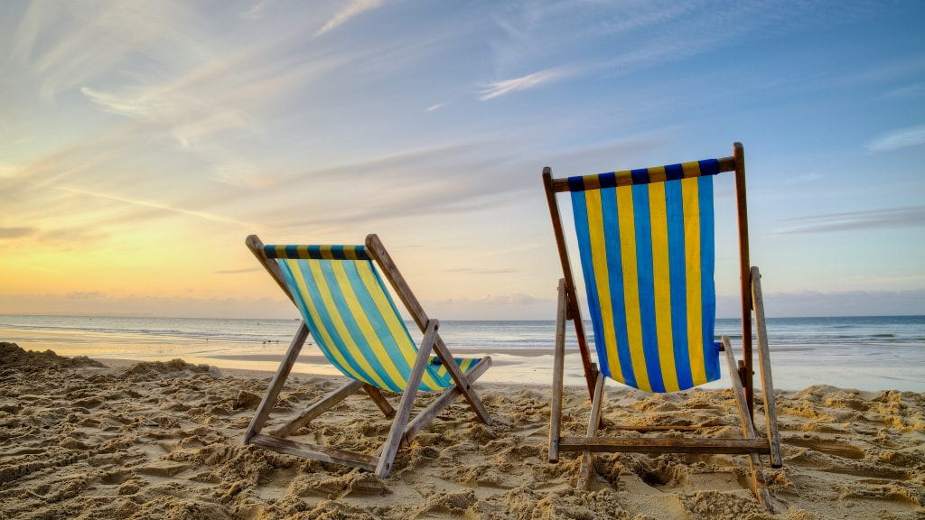  a picture of two beach chairs at sunset
