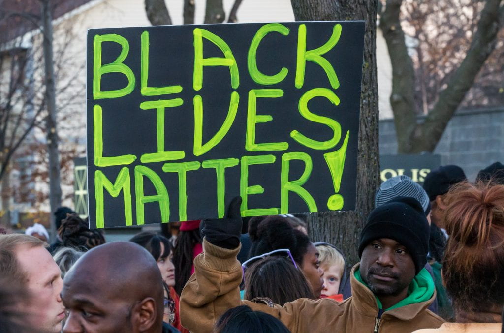 An activist holds a "Black Lives Matter" signs outside the Minneapolis Police Fourth Precinct building following the officer-involved shooting of Jamar Clark on November 15, 2015. Source: Tony Webster, Creative Commons 