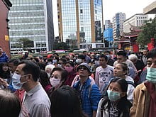 An image of a crowd of people in Wuhan, China. They are all wearing masks as a response to the COVID-19 pandemic.