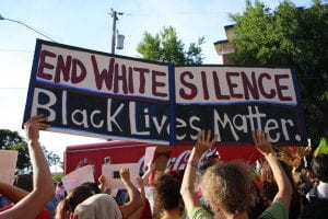 Protest sign reads "End White Silence. Black Lives Matter"
