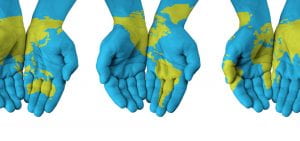 Three pairs of hands painted blue and green to represent the earth