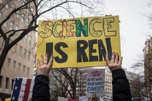 Person holds up sign that reads "Science is Real"