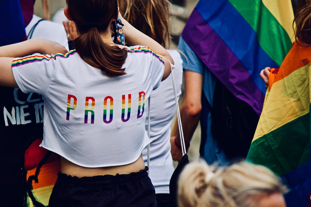 Image of a woman whose t-shirt reads "PROUD" in rainbow letters
