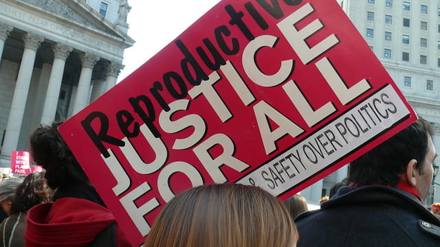 A protest sign that reads "reproductive justice for all"