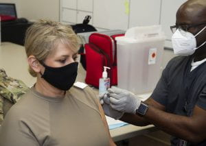 A woman gets her first COVID-19 vaccine