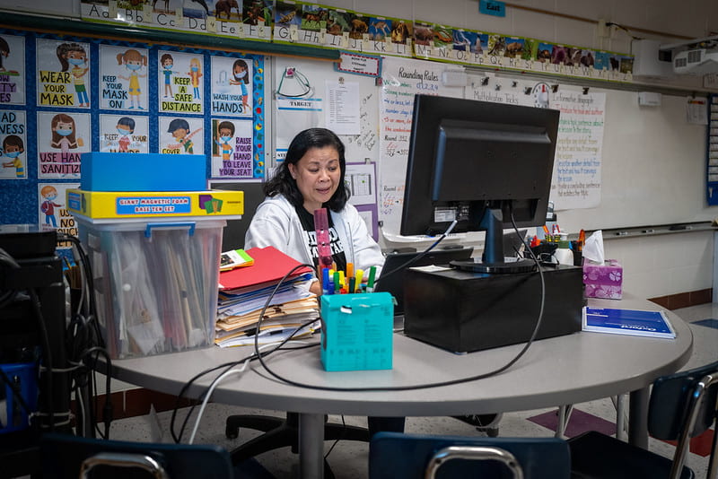 A teacher in an empty classroom teaching online school
