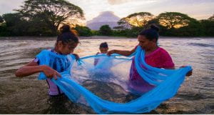 Photo of Nicaraguan mother and daughters fishing with net in river