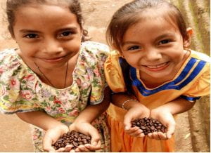 Photo of two little girls holding beans and smiling
