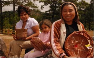 Photo of Nicaraguan women and child holding up woven baskets