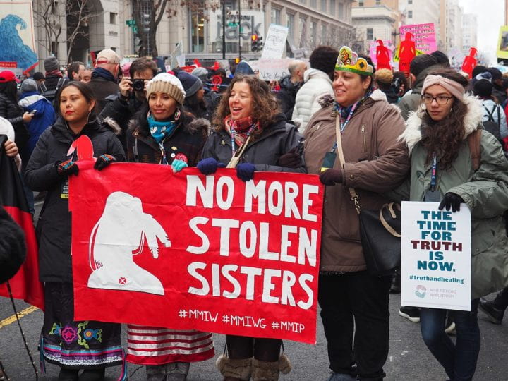 Marchers holding a banner that says "No more stolen sisters"