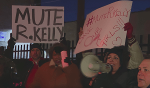 people protest outside with #MuteRKelly signs