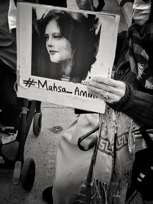 A protestor holds up a photo of Masha Amini