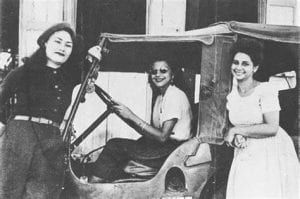 The Mirabal Sisters standing next to a vehicle