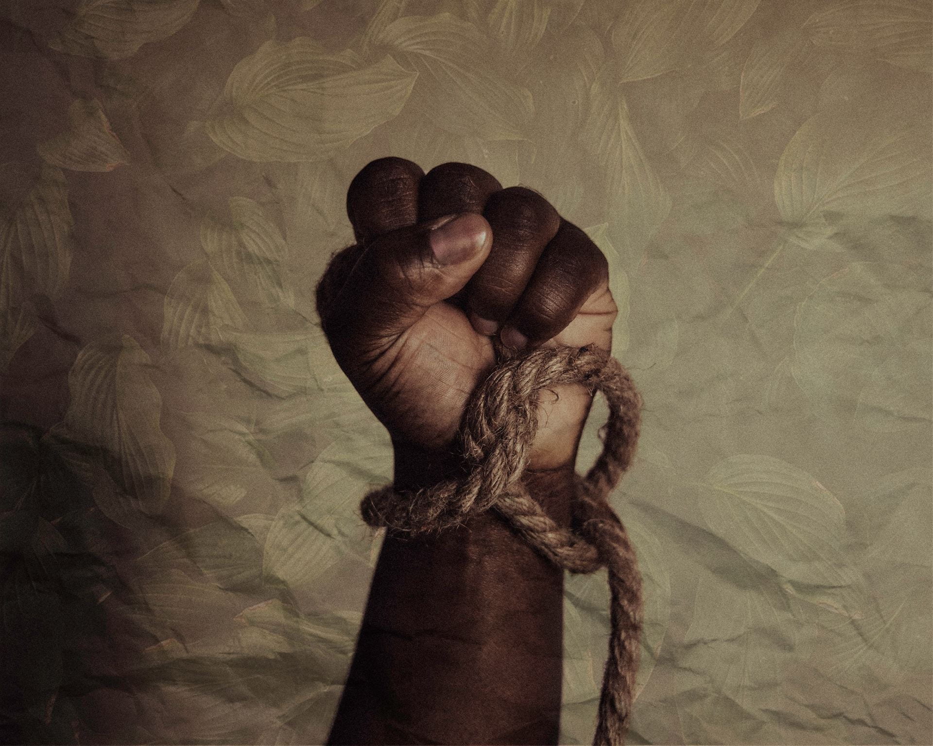 A hand fisted upward with a rope wrapped around the wrist. This is a symbol of Juneteenth, the national celebration of the emancipation of slavery.