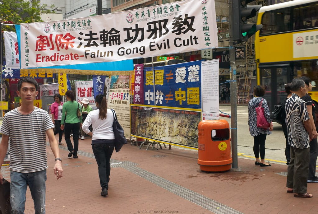 A sign on a busy Chinese street reads, “Eradicate-Falun Gong Evil Cult.” The sign is sponsored by Hong Kong Youth Care Association Limited.