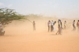 Dust storm in Kenya; men shield their eyes