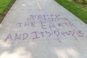 A spray-painted message on South River walking trails that reads “Stop Destroying the Earth and Its People.” 