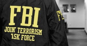 An image of the back of an unknown person with a jacket that reads “FBI Joint Terrorism Task Force.”