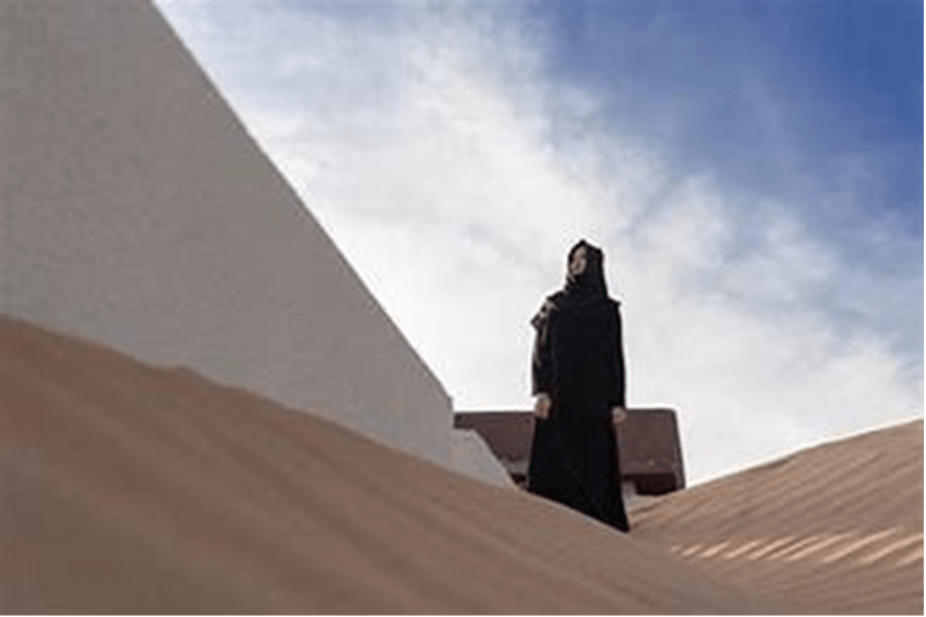 A woman gazing out into the desert, dressed in a black abaya and hijab.Source: Yahoo Images

