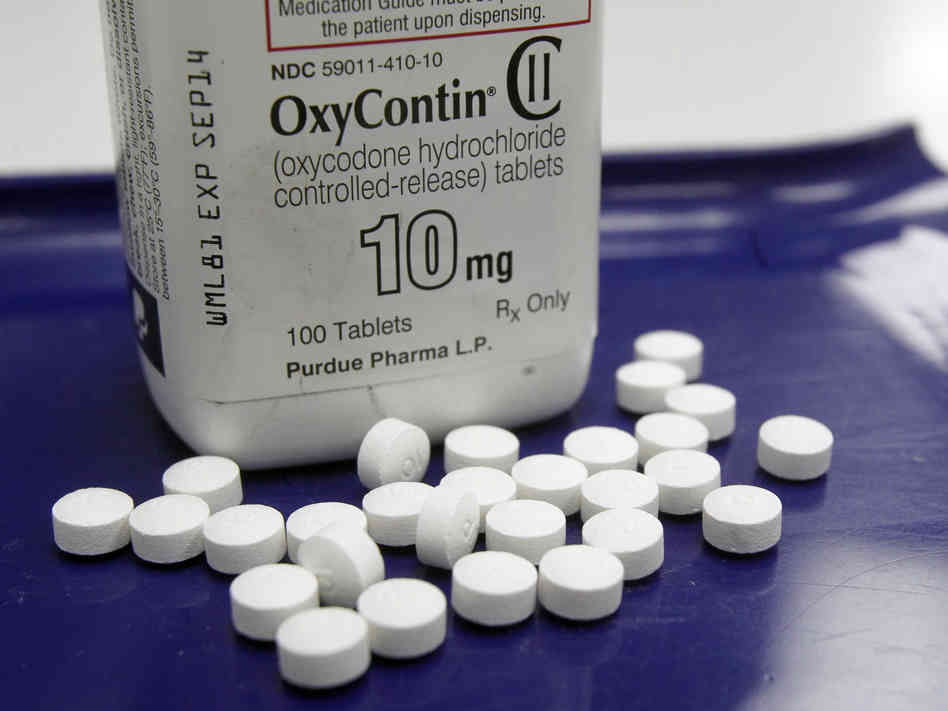Alternate Text: Image of white OxyContin bottle with white pills laid out in front. Source: Flickr 