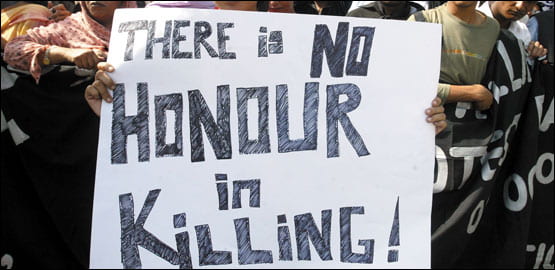 An image with a group of people holding up a banner that reads, "There is no honor in killing!"