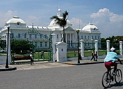 A white building with domed roofs and a green gate