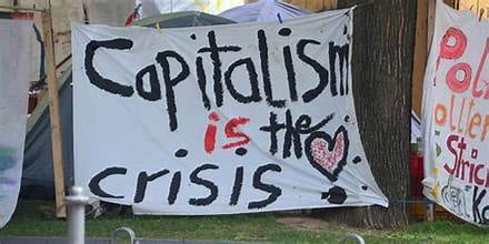 Painted sign that reads "Capitalism is the crisis" in black and red text.