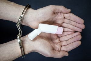 Handcuffed hands with inhaler 